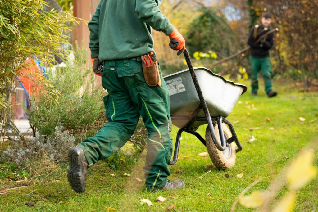 Jardinero con carretilla trabajando en un jardín